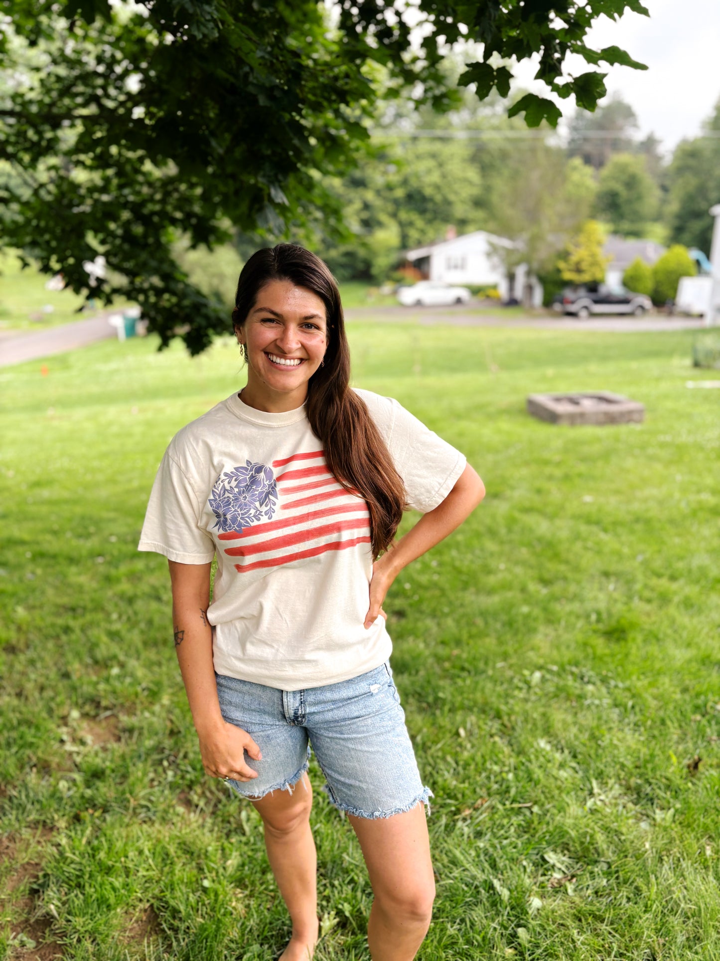 woman smiling at camera wearing fourth of july shirt with blue flowers and red stripes